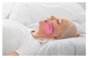 A woman lying on her back, snoring because of sleep apnea.