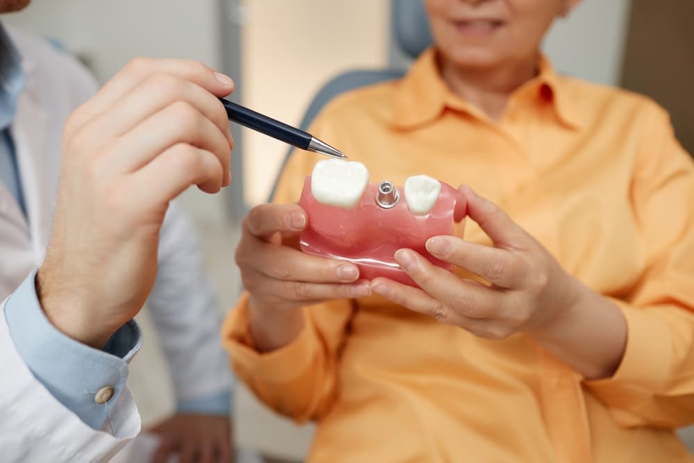 Older woman having a consultation with her dentist about sinus lift with bone graft to support her dental implant.